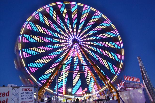 One of several ferris wheels light up at night during the NC State Fair on Saturday, Oct. 17, 2015.
