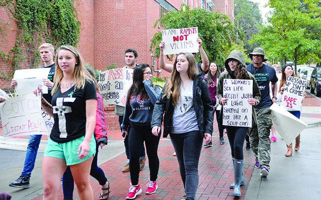 Participants of the SlutWalk charge across campus with posters aiming to stop victim blaming during rape cases Thursday. The walk started at Talley Student Union and proceeded across campus and along Hillsborough Street.