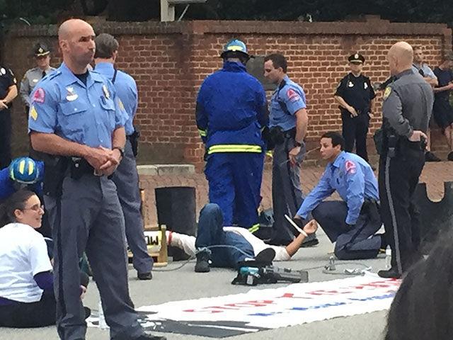 Firefighters set up to cut a hole in the PVC pipes that the protesters bound themselves to.