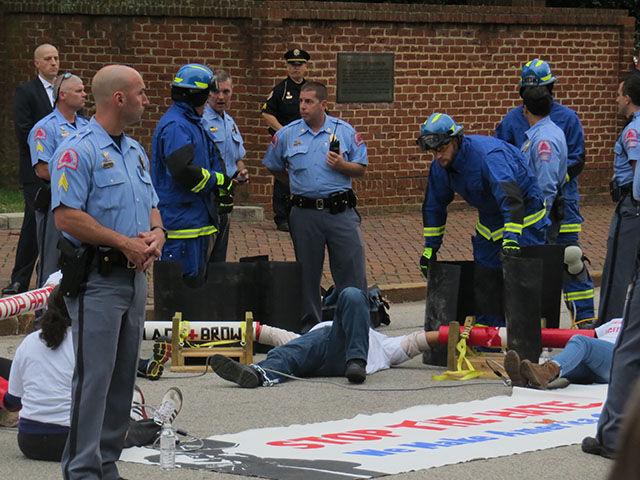 Firefighters cut the PVC pipes binding the protesters, being careful to make sure they don't cut them or get debris in their eyes.&#160;