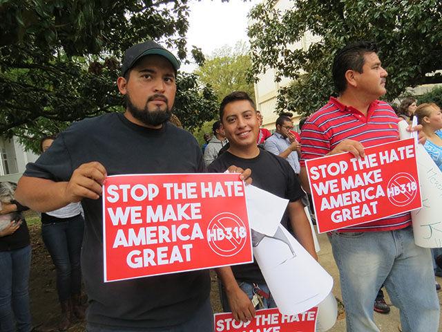 Edmundo Castawona and Anthony Martinez hold signs reading &#8220;stop the hate; we make America great&#8221; in front of the Governor&#8217;s Mansion on Thursday. &#8220;We&#8217;re working to get out of trouble with the government&#8212;we help the economy,&#8221; Castawona said.