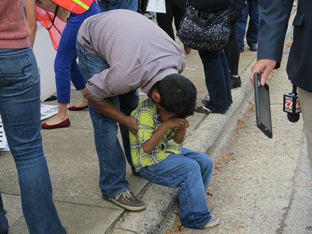 A young Hispanic boy is consoled by family during the protest in front of the Governor&#8217;s Mansion on Thursday.