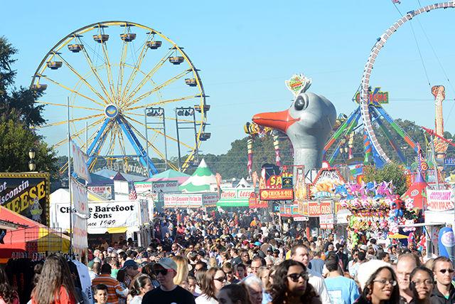 Fairgoers slowly make their way through a congested midway Oct. 25, 2014, at the North Carolina State Fair.