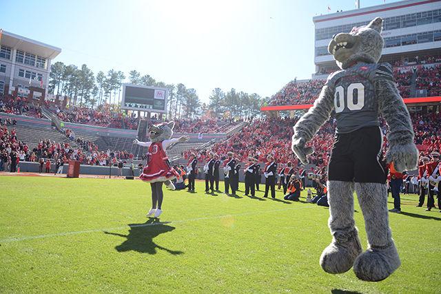 Mr. and Mrs. Wuff cheer for the football team as the team rushes te field at the game against Syracuse on Saturday November 22nd.