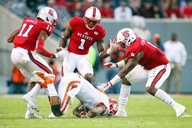 Graduate cornerback Juston Burris, graduate safety Hakim Jones, and redshirt sophomore linebacker Jerod Fernandez crowd Clemson's quarterback Deshaun Watson forcing him to slide. The three defensive players combined for 25 tackles in the 56-41 loss in Carter-Finley stadium on Oct. 31.