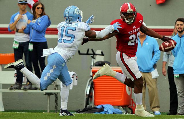 Sophomore fullback Jaylen Samuels stiff arms a Carolina defender on the way to a 64 yard gain at Carter Finley Stadium on November 28. Samuels had 97 of the wolfpacks 514 total yards in the contest. The wolfpack fell to the tarheels 45-34.