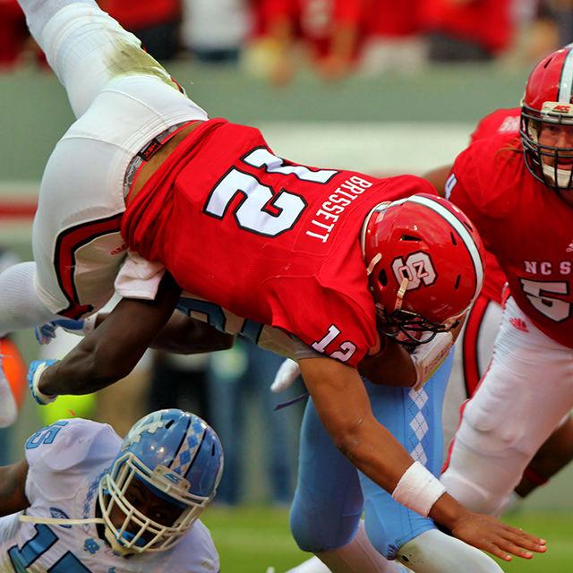 Redshirt senior quarterback Jacoby Brissett hurdles into the endzone for a touchdown against UNC-CH at Carter Finley Stadium on November 28. Brissett was responsible for 334 of the wolfpack's 514 total yards. He finished the game with 128 yards rushing and 206 yards passing. The pack lost the game 45-34.