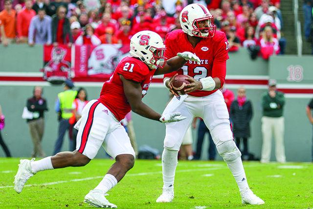 Redshirt senior quarterback Jacoby Brissett fakes the handoff and looks downfield to attempt a throw against the Clemson defense. Brissett finished the game with three touchdowns and 254 yards on 24-of-41 throwing as well as eight carries for 34 yards and a rushing touchdown. The Wolfpack fell to the Tigers 56-41 in Carter-Finley Stadium, on Oct. 31.