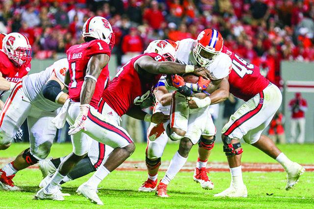 The Wolfpack defenders fail to make a tackle against the Clemson offense when attempting to run past the line of scrimmage. The NC State defense let up 623 yards, 27 first downs, five throwing touchdowns, and two rushing touchdowns against the Clemson Tigers. The Wolfpack fell to the Tigers 56-41 in Carter-Finley Stadium at NC State, on Oct. 31.