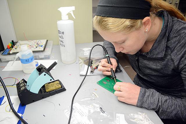 Lydia Ashburn, a freshman in the college of engineering, solders an ECG kit at the Engineering World Health (EWH) club build day that took place on Tuesday, December 1st. 'I'm soldering an ECG kit to be sent to medical students in developing countries. I joined Engineering World Health because I am interested in world health and healthcare in developing countries.' said Lydia. EWH NCSU chapter is an engineering club that meets twice a month and is part of a global organization that focuses on global health. EWH also