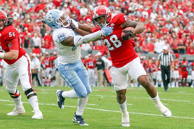 Sophomore runningback Jaylen Samuels stiffarms a UNC defender in the first half. Samuels finished with 3 carries for 6 yards and 6 receptions for 97 yards. The NC State Wolfpack fell to the UNC Tarheels, in the last home game of the season, 45-34 at Carter-Finley Stadium on November 28, 2015.