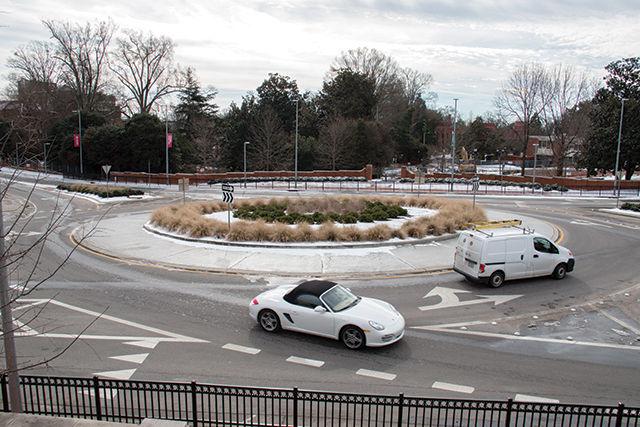 A white car exits the traffic circle at the intersection of Hillsborough Street and Pullen Road as another car continues around the circle on January 25, 2016. City planners are developing plans to add two more traffic circles to Hillsborough Street. Some local residents are opposed to this idea.