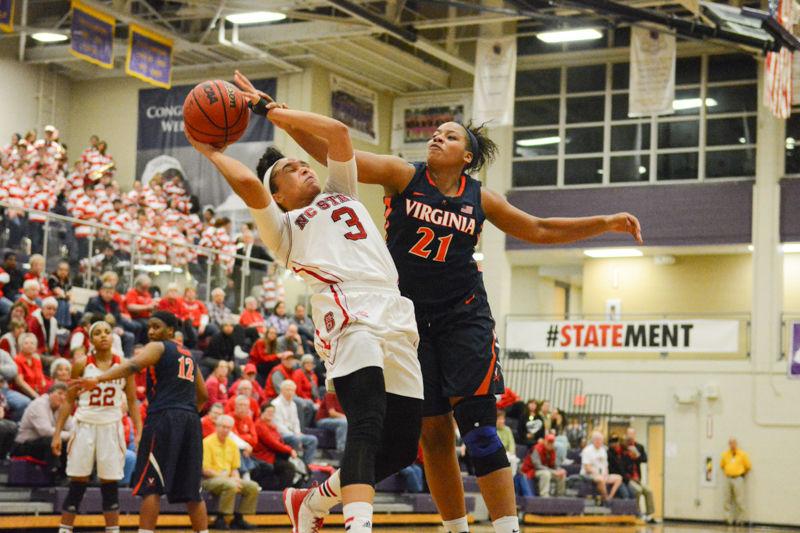 Junior guard Miah Spencer attempting a two pointer while being blocked by a player from Virginia. Spencer made a total of 5 of 8 shots. The girls basketball team had a win over Virginia of 63-52 in Holliday Gymnasium at Broughton High School on Wednesday, Jan. 27 2016.