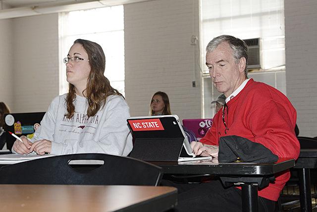 Dean of College of Humanities and Social Sciences Jeff Braden takes notes on zines and how they are related to modern communication technologies on a tablet while sitting next to Taylor Bunten, a junior studying communication, during Communication and Technology class in Daniels Hall Tuesday, Jan. 26,2016. Braden was filling in for senior studying political science and communication Courtney Ross as part of an event called "Dean for a Day" and happened to sit in the exact same seat in which Ross normally sits. According to Braden, he originally came up with this idea of switching places for a student 5 years ago and wanted for a student to see what it was like to be a dean and for him to see what it's like being a student. "This is the best day of my year! I get to be an undergraduate all over again-and take courses and learn from instructors I never had when I was in college" Braden said.