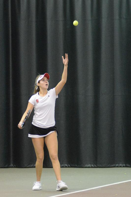 Freshman Amanda Rebol tosses the tennis ball in the air to serve to her opponents during the doubles match. Rebol and Joanna Nalborska won 7-6 (7-5) against Virginia Commonwealth University at J.W. Isenhour Tennis Center on Sat., January 30th, 2016.