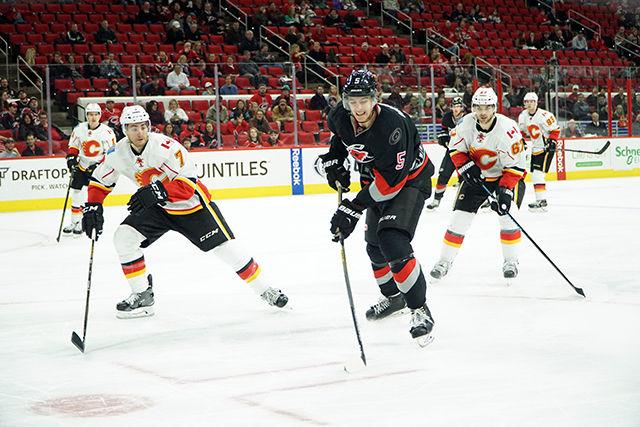 Carolina Hurricanes defender Noah Hanifin clears the puck past Calgary defender TJ Brodie. The Hurricanes defeated the Calgary Flames 5-2 at the PNC Arena on 1/24/1016.