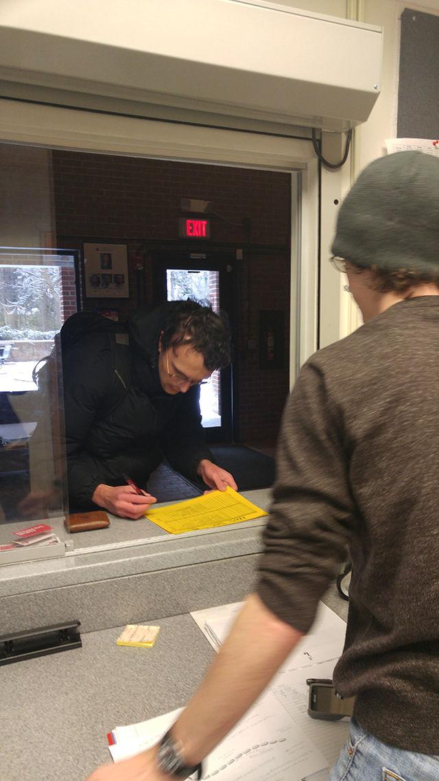 Logan Green, a senior studying computer science, signs in for emergency temporary housing at the 24-hour service desk at Wood Hall on Saturday, Jan. 23, 2016.&#160; Green lives at Avent Ferry Complex but the buildings lost power last night at 8:15pm and isn&#8217;t expected to return until Monday.