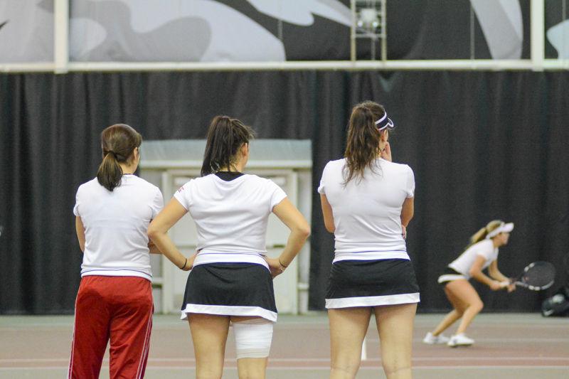 Senior Taylor Zaytoun, Sophomore Tayla Stenta, and Freshman Bianca Moldovan watch as their teammates finish a match against Virginia Commonwealth University at J.W. Isenhour Tennis Center on Sat., January 30th, 2016.