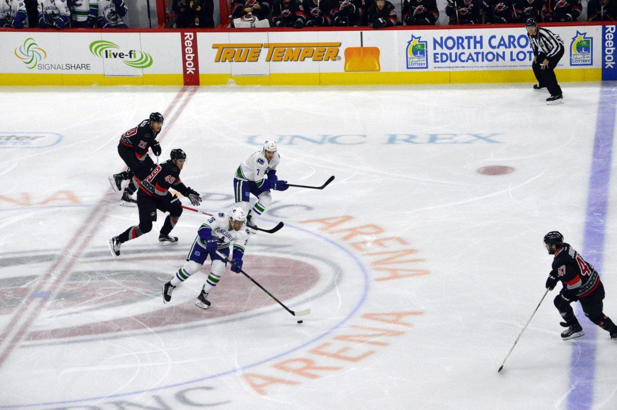 Vancouver Canucks forward, Emerson Etem, advances the puck into Carolina Hurricanes territory. After the first period, the Canucks took an early lead during the first period of the game on Friday, January 15th, 2016 in PNC Arena -- ending the first period with a 1-0 lead. This was Vancouver's 45th game this season, winning the away game with a 3-2 score in overtime.