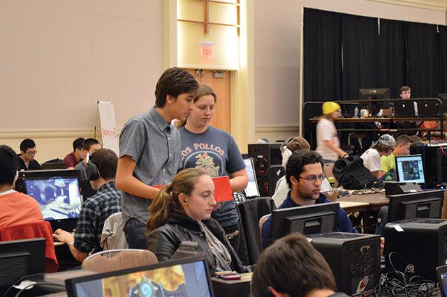 Connor McKinney, a junior studying biological sciences, and Deborah Mitchell, a sophomore studying biological sciences, hand out business cards and candy to participants on the first day of the Clash of the Carolinas, a sporting tournament. "I'm not actually advertising anything except for myself. I'm just trying to find people to play video games with. The hamster has the appeal of, 'Hey, I'm not creepy, just take the card.' I'm really hoping to meet a lot of people to play with, and this seems like the best place to meet people who play these types of games."