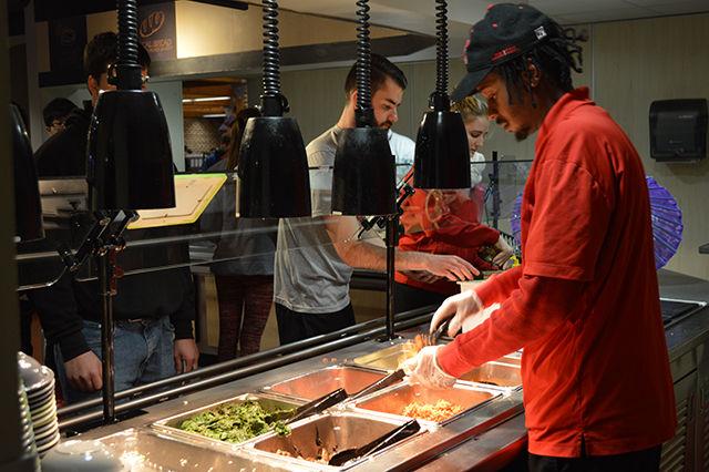 Attendees line up to get, "A Taste of Korea" at Fountain Dining Hall Wednesday. Various cultural staples &#8212; such as jabchae, spicy doen jang soup and kimchi were featured in the food line-up.
