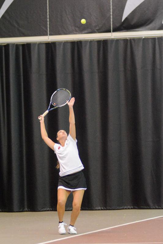 Senior Joanna Nalborska tosses the tennis ball in the air for her serve. Nalborska and Amanda Rebol won 7-6 (7-5) against Virginia Commonwealth University at J.W. Isenhour Tennis Center on Sat., January 30th, 2016.