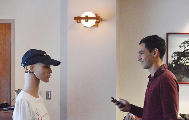 Diego Castedo Pena, a freshman studying mathematics, attempts to hold a conversation with KEN, a robot brought to the D.H. Hill Library by the IEEE Robotics and Automation Society Wednesday. The Institute of Electrical and Electronic Engineers has chapters all over the world that "promote the engineering process of creating, developing, integrating, sharing and applying knowledge" to the public. The Eastern North Carolina Chapter of IEEE brought KEN, along with several pieces of robot memorabilia, to NC State and allowed students in the NC State Scholars Program to interact with KEN and test out his ability to interact with people. KEN was built using mostly donations and volunteer labor, and the improvements that will continue to be made on KEN will mostly be funded with future donations to the program. The robot exhibit will be on display in D.H. Hill Library until the end of February.