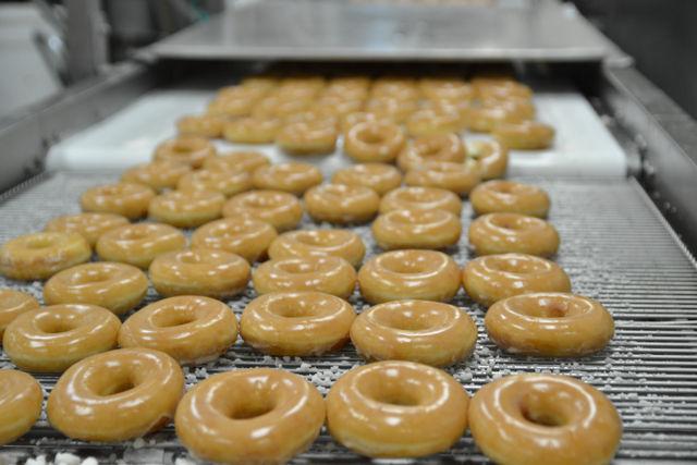 Dozens of rows of Krispy Kreme doughnuts at the Downtown Raleigh store wait to be packaged by employees at the end of the production line where they will then be driven to all of the stoes in the Wake Countuy and Johnston County areas for customers to enjoy.