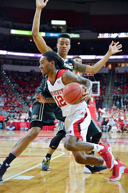 Junior guard Anthony "Cat" Barber runs around freshman forward John Collins from Wake Forest to attempt to score during the basketball game on Saturday, Feb 13, 2016. Barber scored 38 out of NC State's 99 points, beating the Wake Forest's 88.