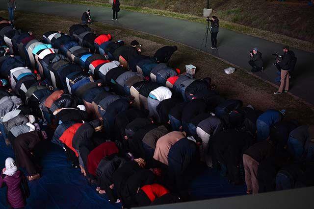People stand in lines as they were lead in prayer by Imam Mohamed AbuTaleb during the 'Our Three Winners' memorial on Feb 10, 2016 that took place on Stafford Commons.