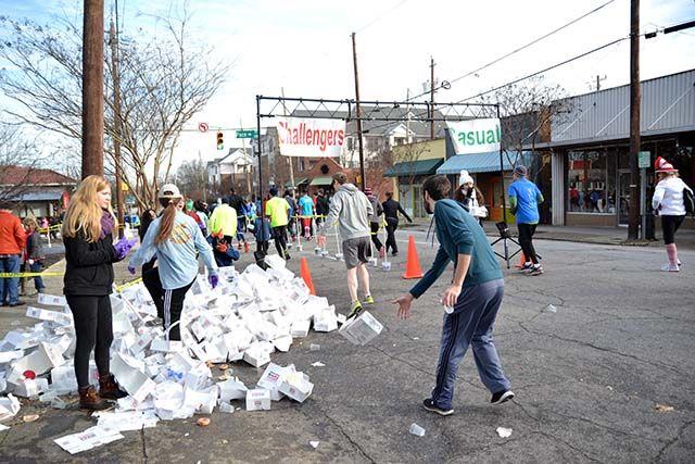 Participants of the Krispy Kreme Challenge throw their empty doughnut boxes before continuing the five mile race back to the Belltower on Saturday, Feb. 6th, 2016.