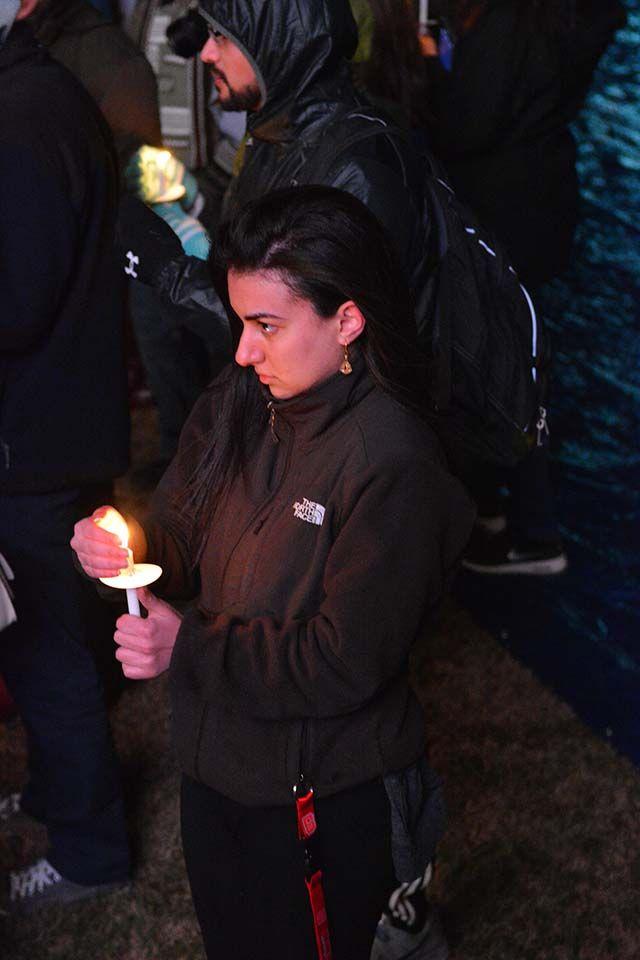 Dana Elhertani, a student at UNC Chapel Hill, sheilds her candle from the wind during the memorial for Our Three Winners. The memorial, which was held Wednesday night, Feb 10, 2016 had several hundred students attend to honor the memory of Deah, Yusor, and Razan.
