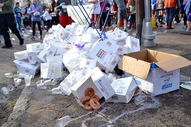 A pile of empty and not empty dougnut boxes collects by the street outside of the Krispy Kreme on N. Persons St. Thousands of participants of the Krsipy Kreme Challenge participated by running the five mile race and eating a dozen doughnuts.