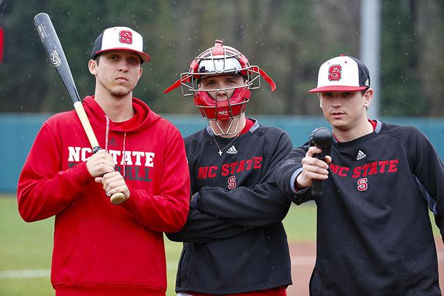 Dalton Greco, a junior studying sports management, Kyle May, a junior studying business administration, and Trey Baker, a senior studying communication, managers for the baseball team, pose for a picture on the baseball field.