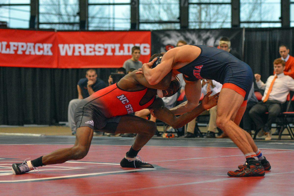 Redshirt freshman Jamal Morris lunges for his opponent's legs in the Wolfpack's meet against No. 17 Virginia. While Morris lost his bout, the Wolfpack were able to rout Virginia 35-7 at Dorton Arena Jan. 17 in Raleigh.