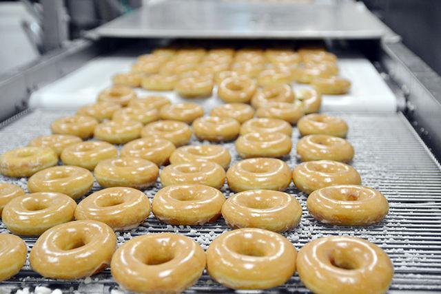 Dozens of rows of Krispy Kreme doughnuts at the Downtown Raleigh store wait to be packaged by employees at the end of the production line where they will then be driven to all of the stoes in the Wake Countuy and Johnston County areas for customers to enjoy.