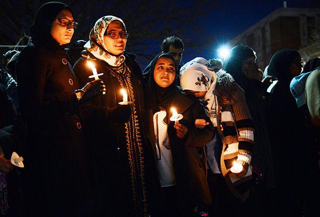 Members of the Muslim Student Association stand together in support and listen to friends and family speak to the crowd during the candle light vigil Wednesday night. Among the speakers, UNC and NC State's chancellors, the mayor of Chapel Hill and members of the MSA spoke.