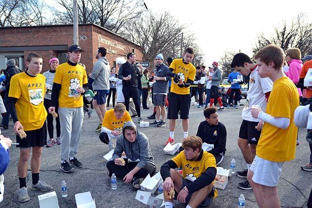 Members of the Apex High School soccer team eat a dozen doughnuts each outside of Krispy Kreme during the five mile Krispy Kreme Challenge.
