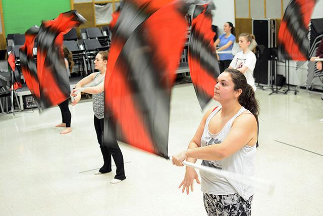 Celia Gentry, a sophmore study first-year engineering, and her teammates on NC State's Wintergurard are warming up with a routine Wednesday. They have been practicing in Price Hall this week in preparation for their third competition this weekend.