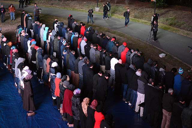 People stand in lines as they were lead in prayer by Imam Mohamed AbuTaleb during the 'Our Three Winners' memorial on Feb 10, 2016 that took place on Stafford Commons.