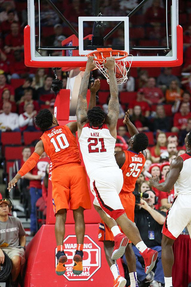 BeeJay Anya dunks over two Clemson defenders during the Clemson vs NC State basketball game at PNC Arena on February 20, 2016.