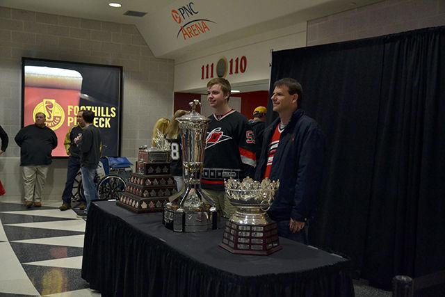 Carolina Hurricanes fans pose for a photo with the Conn Smythe, Prince of Wales and Selke trophies during the game against the Pittsburgh Penguins on Friday, Feb 12, 2016.