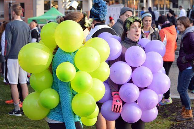 NC State Alumni Leah Staley and Holly Goode converse in their grape costumes before the start of the race. This is Staley's first year running the Krispy Kreme Challenge and Goode's second. "I had always wanted to do it" Staley says, "and [Goode] had done it before so she said she'd do it with me."