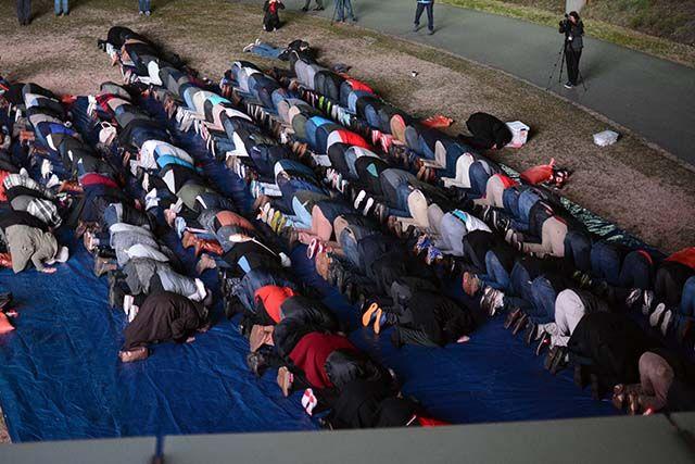 People stand in lines as they were lead in prayer by Imam Mohamed AbuTaleb during the 'Our Three Winners' memorial on Feb 10, 2016 that took place on Stafford Commons.