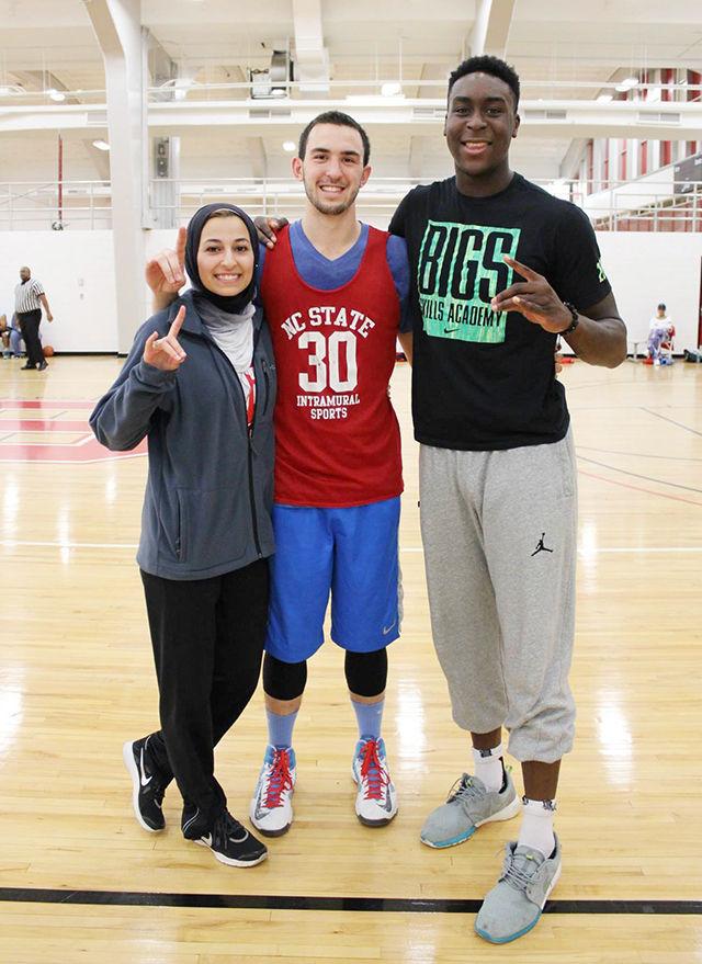 Malik flashes the Wolfpack hand gesture with Deah and Yusor after a 3-on-3 basketball Tournament in Carmichael Gymnasium at NC State. Malik and Deah met through the local muslim community and their love ofbasketball.