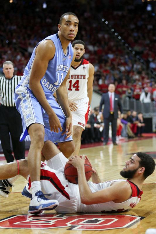 Cody Martin gets tied up with Brice Johnson and falls in the second half. The NC State Wolfpack lost to the UNC tarheels, 80-68, at PNC Arena on February 24, 2016.