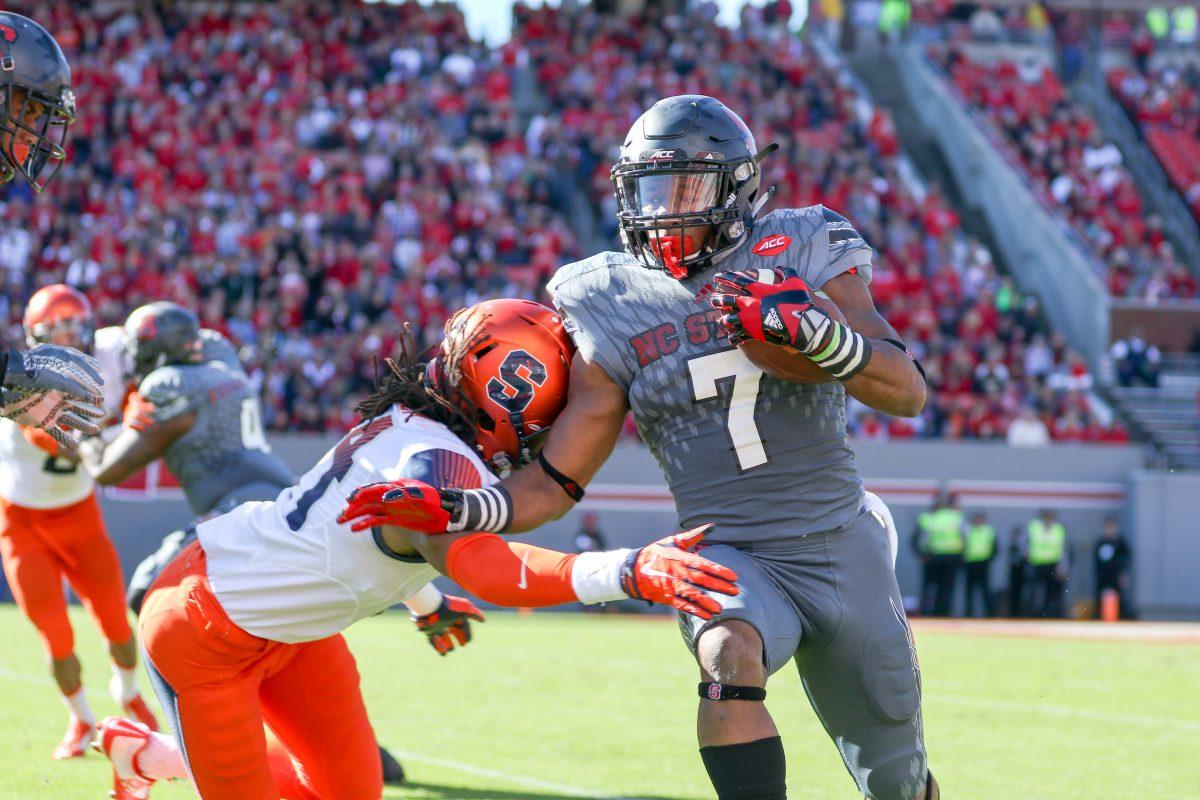 Freshman Wide Receiver Nyheim Hines sprints to the sideline on a kick return, stiffarming a Syracuse defender in the process. Hines finished with 6 rushes for 70 yards and a touchdown, along with 5 receptions for 69 yards. Hines also had 3 kickoff returns for 69 yards. The NC State Wolfpack beat the Syracuse Orange 42-29 at Carter-Finley Stadium on Saturday, November 22, 2015 to go to a record of 7-4 with a conference record of 3-4.