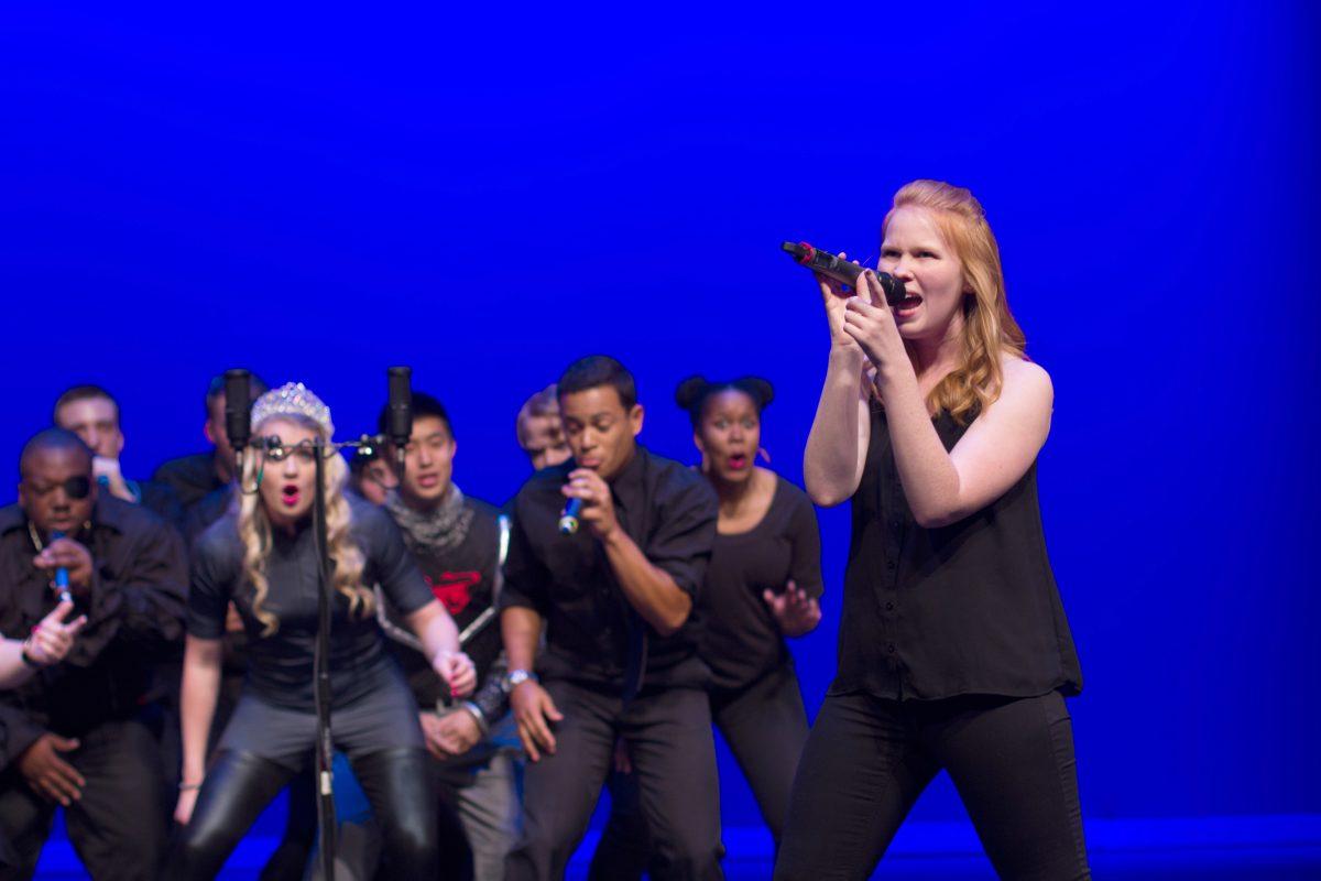 Anna Griffin, a senior studying religious studies, sings a solo while the rest of the group breaks it down during Accapology's Spring Concert at Stewart Theater on March 30, 2016. The concert, called "Writing is Hard: Stories through Song", told the story of a struggling freshman english major trying to finish an assignment as told through twelve acapella performances.