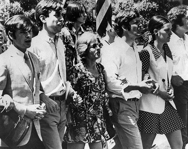 Cathy Sterling (center in flower dress) marches alongside students in a peace rally following the Kent State shootings of 1970. Sterling served as the first female student body president at NC State.