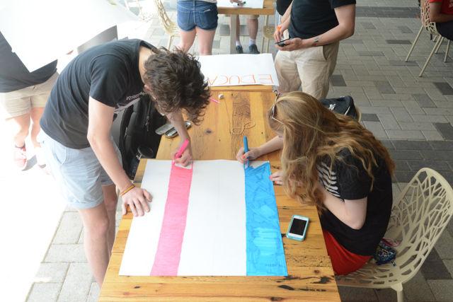 Travis Herrington, a sophomore majoring in english, and Chloe Holland, a sophomore majoring in animal science, color the trans flag to protest Margaret Spellings's visit to NC State's campus on Wednesday, April 20th. Protesters gathered on Stafford Commons and then in the lobby of Talley Student Union to show their opposition to Spellings taking the position of president of the UNC public university system.